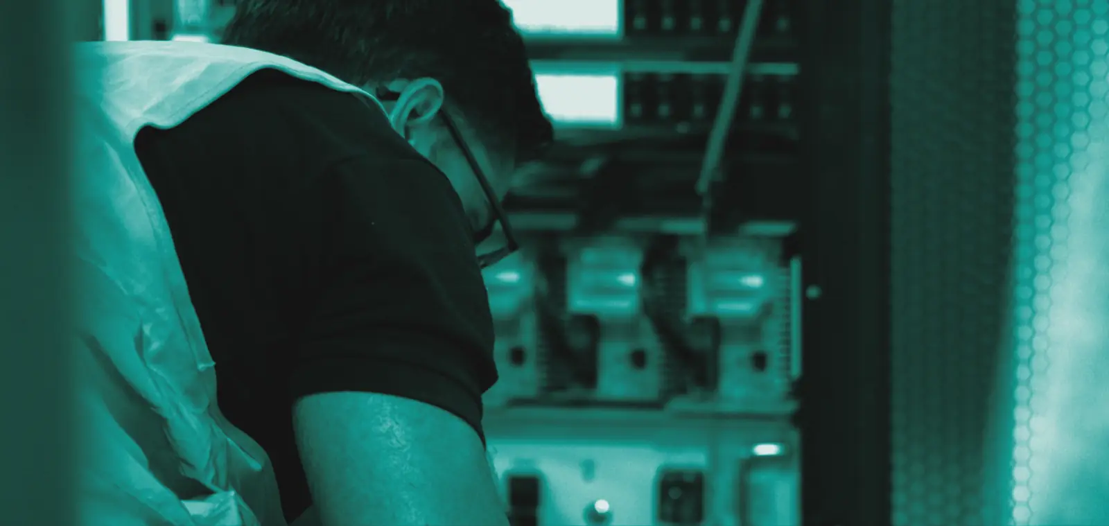Engineer working on network equipment in a server cabinet